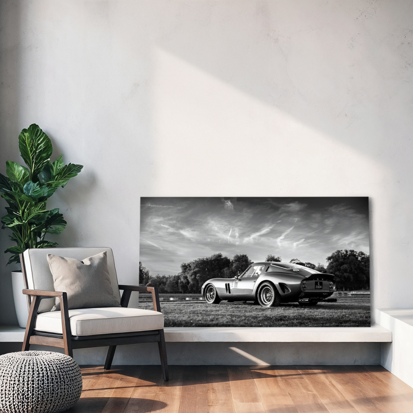 A black and white photograph of a vintage silver Ferrari 250 GTO parked on grass.