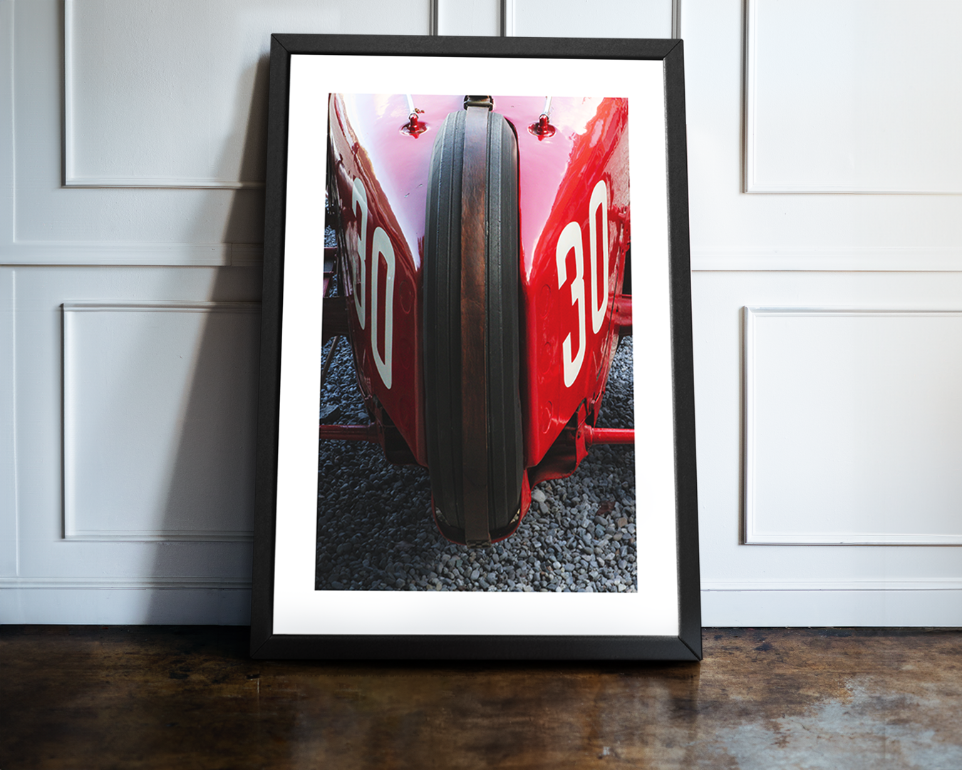 A close-up photograph of the front of a red vintage Alfa Romeo P3 racing car, featuring a single front tire and the white number 30 on the bodywork.
