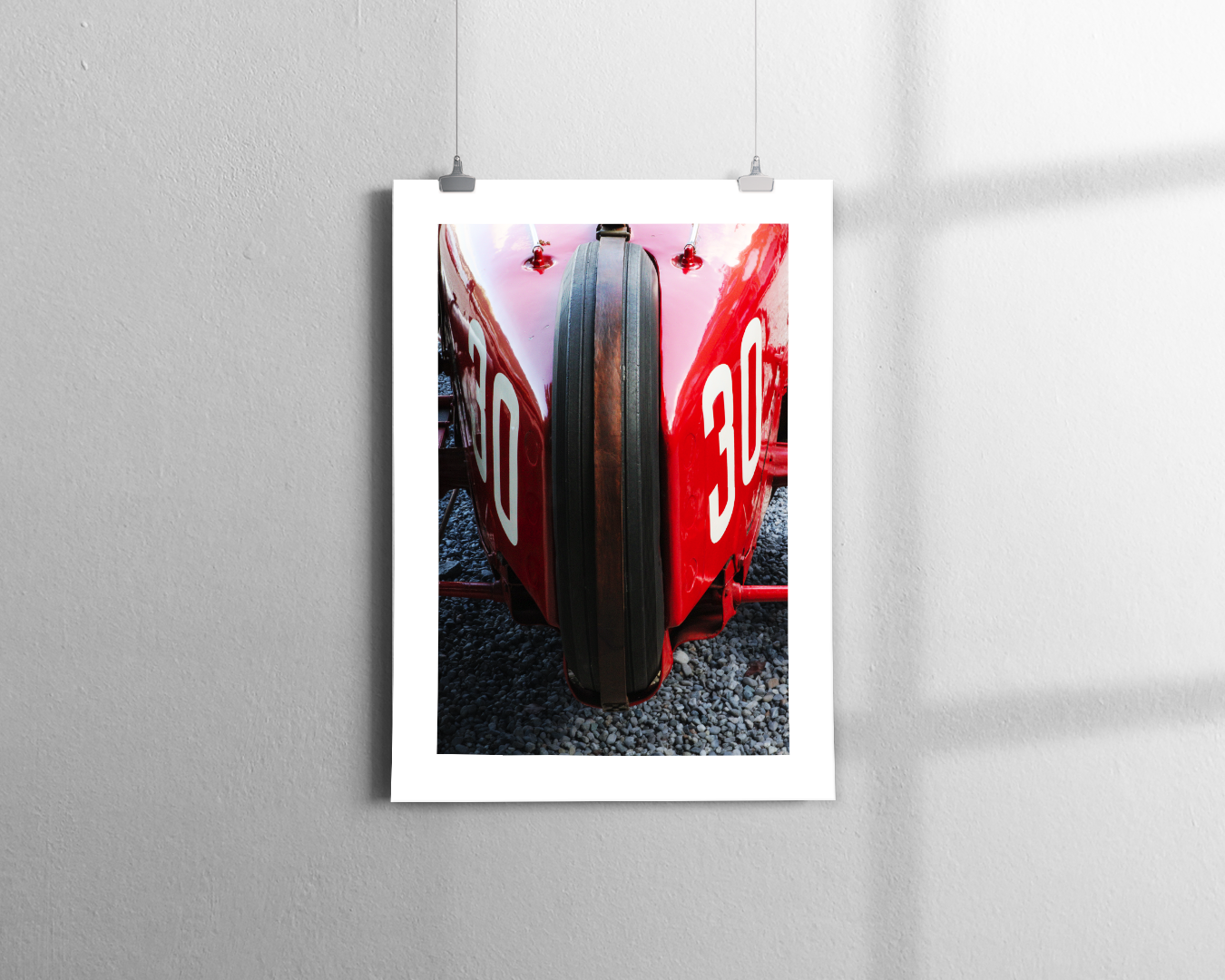 A close-up view of the front of a vintage red Alfa Romeo Tipo B P3 racing car with the number 30 on the sides, parked on gravel.