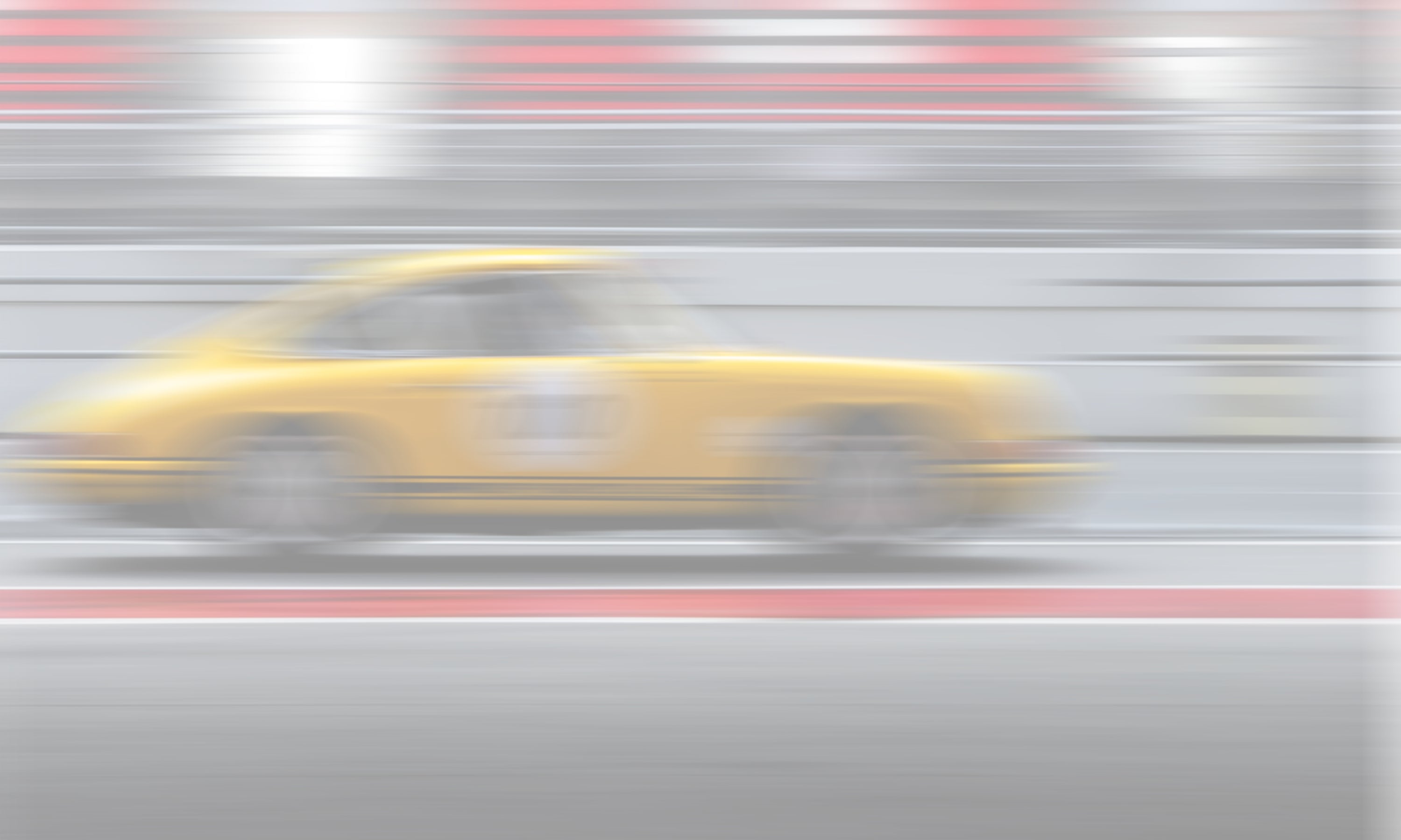 Cinematic motion blur of a racing car at speed, capturing the raw emotion of motorsport for Invictus Heights.