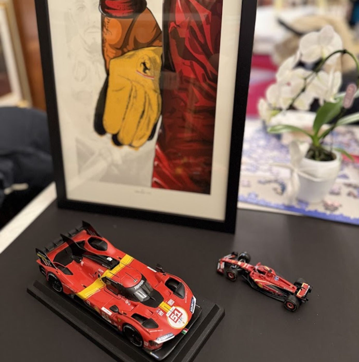 Framed Lewis Hamilton Ferrari fine art print displayed alongside curated motorsport scale models for serious collectors.