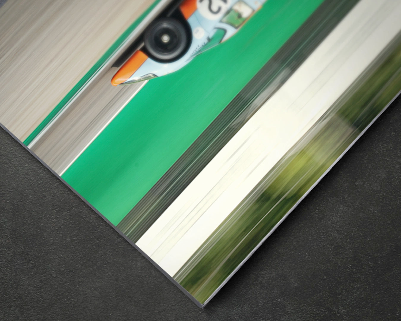 Close-up of Porsche 917K Imola aluminium print showing motion blur and Gulf livery detail on satin aluminium surface