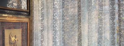 A calm, dark pan revealing a museum-grade automotive artwork of Lewis Hamilton in Milan.